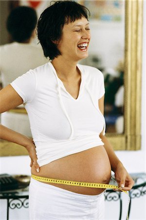 short haired women pregnant - Pregnant woman measuring stomach with measuring tape, laughing Stock Photo - Premium Royalty-Free, Code: 695-05769740
