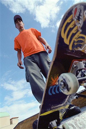 patinador - Skateboarder perched at edge of ramp, low angle view of board Foto de stock - Royalty Free Premium, Número: 695-05769851