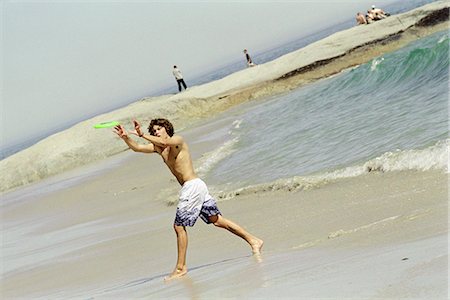 Male catching frisbee on beach Stock Photo - Premium Royalty-Free, Code: 695-05769870