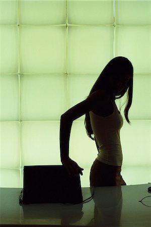 Silhouette of woman closing laptop computer Stock Photo - Premium Royalty-Free, Code: 695-05769921