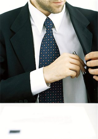 Businessman putting pen into jacket pocket Stock Photo - Premium Royalty-Free, Code: 695-05762156