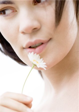 simsearch:695-05777385,k - Woman holding flower next to face, close-up Stock Photo - Premium Royalty-Free, Code: 695-05762368