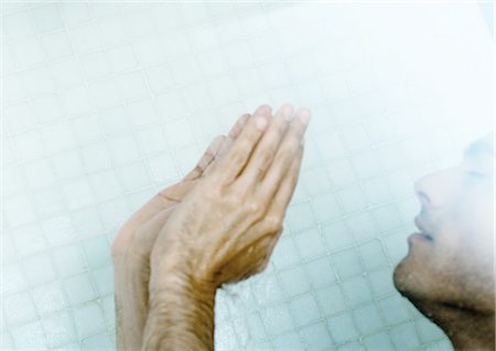 Man in shower with hands up Stock Photo - Premium Royalty-Free, Code: 695-05762391