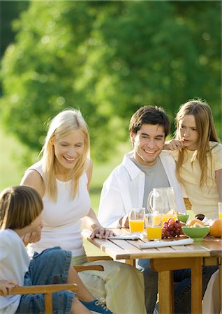 simsearch:632-05554062,k - Family having breakfast outdoors Fotografie stock - Premium Royalty-Free, Codice: 695-05762497