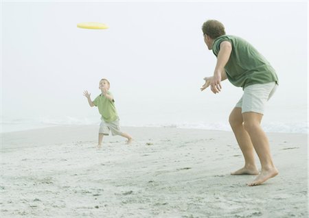 father and son playing catch - Father and son throwing frisbee on beach Stock Photo - Premium Royalty-Free, Code: 695-05762579