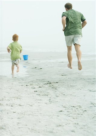 Father and son running on the beach, rear view Stock Photo - Premium Royalty-Free, Code: 695-05762573