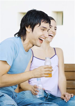 Two young adult friends with bottles laughing Stock Photo - Premium Royalty-Free, Code: 695-05762615