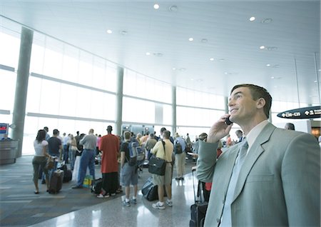 Businessman using phone in airport boarding area Stock Photo - Premium Royalty-Free, Code: 695-05762902