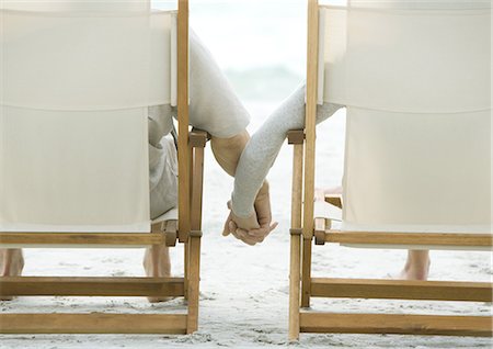 Couple sitting in beach chairs, holding hands, rear view Stock Photo - Premium Royalty-Free, Code: 695-05762932