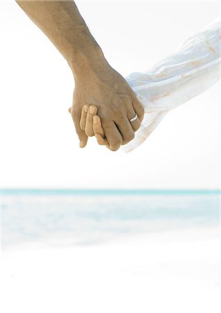 Married couple holding hands on beach, close-up of hands Stock Photo - Premium Royalty-Free, Code: 695-05763153