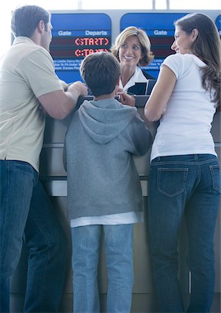 Family standing at airline check-in counter Stock Photo - Premium Royalty-Free, Code: 695-05763298