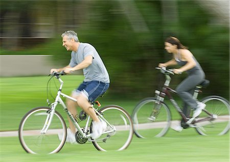 side view of a guy riding a bike - Mature couple riding bikes Stock Photo - Premium Royalty-Free, Code: 695-05763290