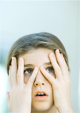 Girl looking through fingers Stock Photo - Premium Royalty-Free, Code: 695-05763357