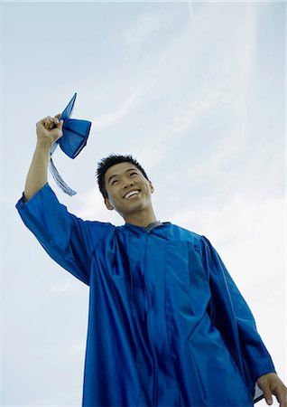 Male graduate taking off cap Stock Photo - Premium Royalty-Free, Code: 695-05763422