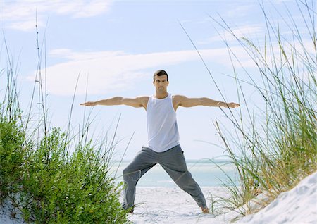 Man doing stretches on beach Stock Photo - Premium Royalty-Free, Code: 695-05763457