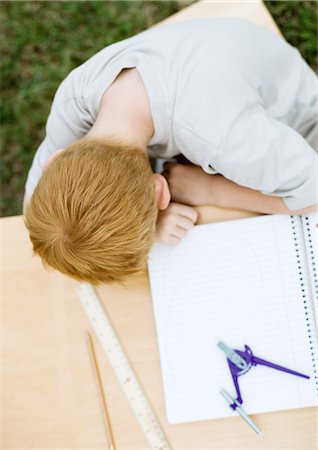 Boy with head on table next to open notebook Foto de stock - Sin royalties Premium, Código: 695-05763607