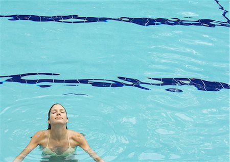 Woman standing in pool, head back and eyes closed, front view Stock Photo - Premium Royalty-Free, Code: 695-05763717