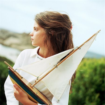 photography of little girl dreaming - Girl holding model boat, outside Stock Photo - Premium Royalty-Free, Code: 695-05774086