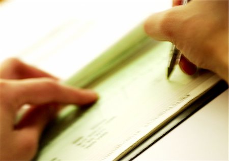 person writing in check book - Hands writing check, close-up, blurred Stock Photo - Premium Royalty-Free, Code: 695-05774132