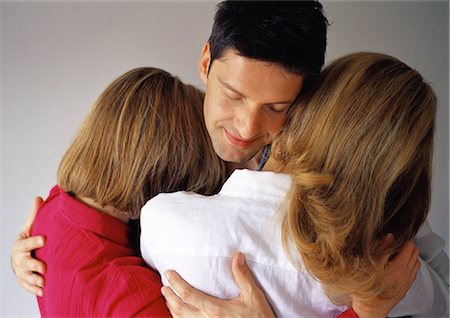 Man hugging two women, eyes closed Stock Photo - Premium Royalty-Free, Code: 695-05774559