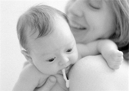 Infant spitting up on mother's shoulder, close-up, b&w Foto de stock - Sin royalties Premium, Código: 695-05774622