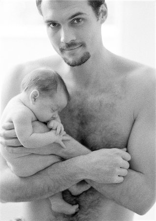 Topless father holding sleeping infant, looking at camera, b&w Stock Photo - Premium Royalty-Free, Code: 695-05774649