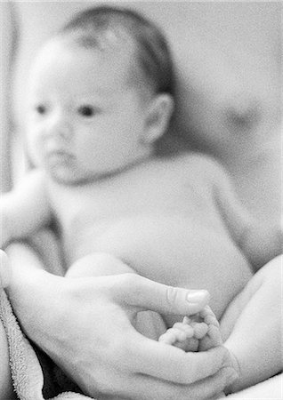 simsearch:632-01141193,k - Infant leaning against mother's chest, mother holding infant's feet in hand, close-up, b&w Foto de stock - Sin royalties Premium, Código: 695-05774655