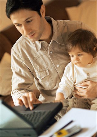Father and baby, father using laptop, baby sitting on father's lap. Stock Photo - Premium Royalty-Free, Code: 695-05774706
