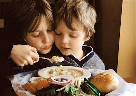 Young boy helping younger brother eat, portrait. Foto de stock - Sin royalties Premium, Código: 695-05774754