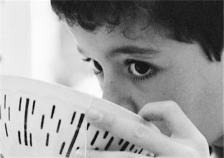 Child drinking from bowl, close-up, b&w. Stock Photo - Premium Royalty-Free, Code: 695-05774762