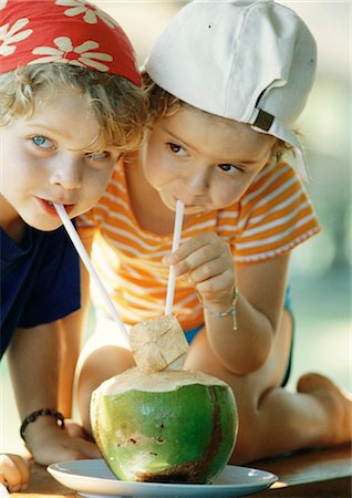 Two children drinking fresh juice through straws, close-up Foto de stock - Sin royalties Premium, Código: 695-05774775