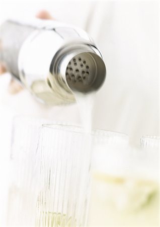 pouring cocktail shaker into glass - Hand pouring cocktails, close-up Stock Photo - Premium Royalty-Free, Code: 695-05774907