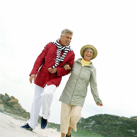 simsearch:695-05775309,k - Mature couple walking arm in arm on beach Foto de stock - Sin royalties Premium, Código: 695-05775289