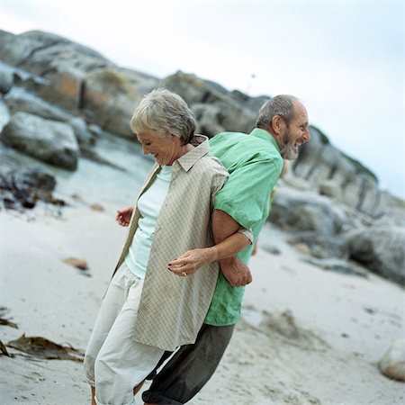senior women stretching on beach - Mature couple standing back to back, arms locked, side view Stock Photo - Premium Royalty-Free, Code: 695-05775296