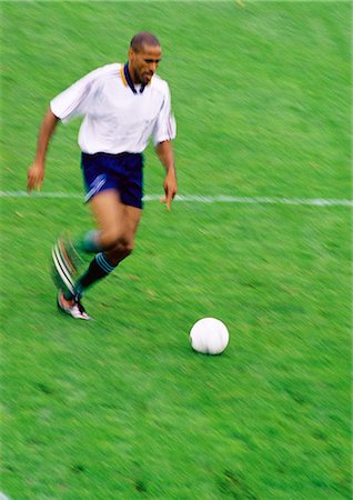 Soccer player running with ball. Stock Photo - Premium Royalty-Free, Code: 695-05775828