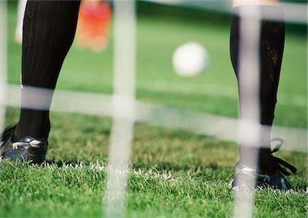 Goal keeper in front of goal area, low section, close-up, blurred. Stock Photo - Premium Royalty-Free, Code: 695-05775841