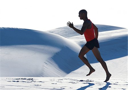 desert endurance - Barefooted man, running across dune, side view Stock Photo - Premium Royalty-Free, Code: 695-05775870