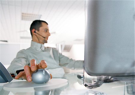 futuristic images of office people at work in the future - Man at desk using cordless mouse Stock Photo - Premium Royalty-Free, Code: 695-05775921