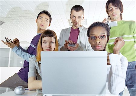 Group of young people gathered around computer Stock Photo - Premium Royalty-Free, Code: 695-05775947