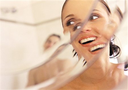 Woman looking at man in mirror, close-up, smiling, distortion Stock Photo - Premium Royalty-Free, Code: 695-05775964