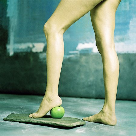 Woman's legs, heel on apple, low section Stock Photo - Premium Royalty-Free, Code: 695-05776030