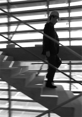 Man on stairs, wearing hard hat, blurred motion, b&w Stock Photo - Premium Royalty-Free, Code: 695-05776089