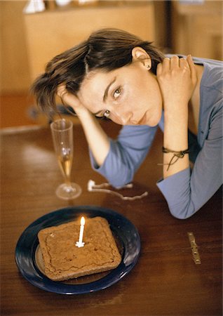 Frau allein am Tisch mit Kuchen und eine Kerze, portrait Stockbilder - Premium RF Lizenzfrei, Bildnummer: 695-05776239