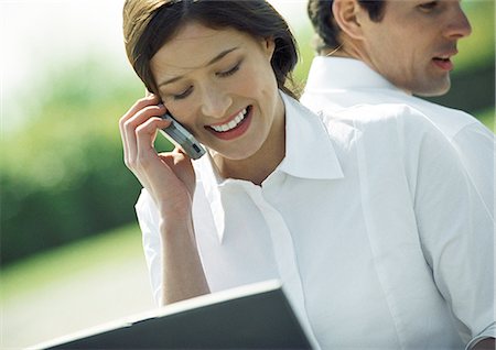 simsearch:695-05776257,k - Businessman and woman back to back, woman using cell phone, head and shoulders, tilt Stock Photo - Premium Royalty-Free, Code: 695-05776293