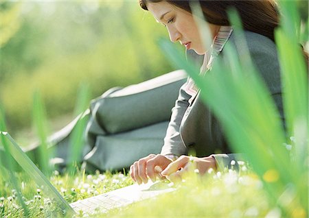 Businesswoman lying on grass with laptop computer Stock Photo - Premium Royalty-Free, Code: 695-05776309