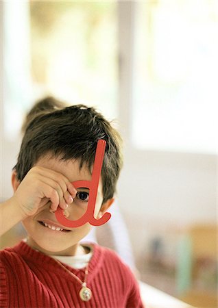 Enfant regardant à travers la lettre en plastique, portrait Photographie de stock - Premium Libres de Droits, Code: 695-05776441