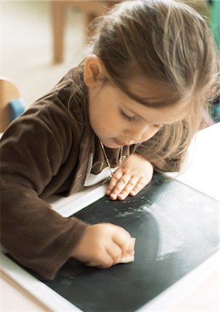 Child cleaning chalkboard Foto de stock - Sin royalties Premium, Código: 695-05776472