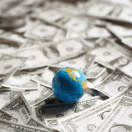 Small world globe on top of U.S. Dollars Stock Photo - Premium Royalty-Free, Code: 695-05776585