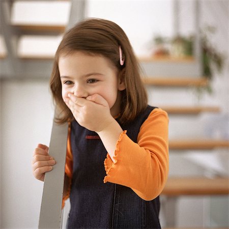 embarrassed kid - Young girl covering mouth with hand, portrait Stock Photo - Premium Royalty-Free, Code: 695-05776653