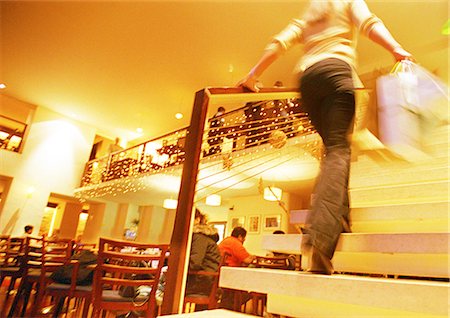 Femme qui marche escalier au centre commercial, food court à l'arrière-plan Photographie de stock - Premium Libres de Droits, Code: 695-05776698